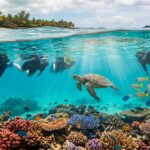 Quatre personnes font de la plongée avec tuba parmi un récif corallien vibrant, une tortue marine et des poissons à l'île Maurice.